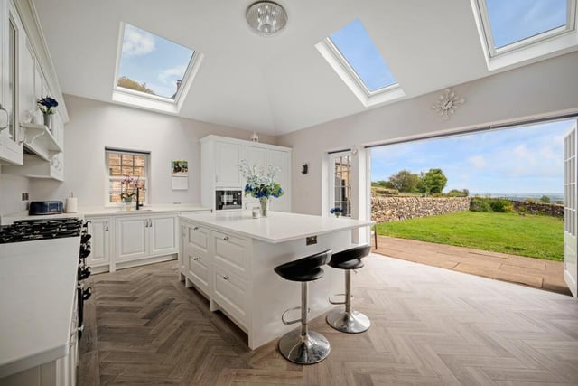 The bespoke kitchen has been designed to maximise natural light with roof skylights and patio doors that open to a spectacular view of the countryside.