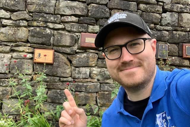 Adam Oxley points to a memorial plaque in honour of his father which reads: "In Loving Memory of Glen Oxley 1955-2019. Hallam FC Player 1977-82. Will Always Be Missed."