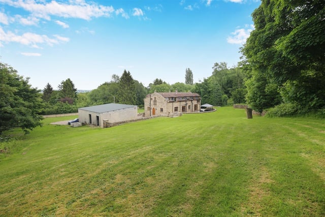 Looking across the swathe of lawn to the imposing property and its outbuildings.