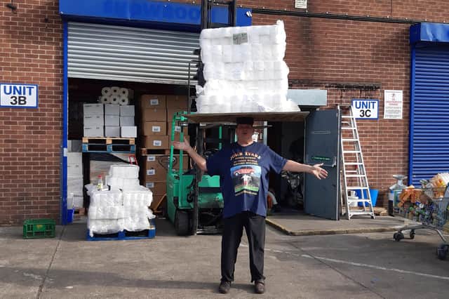 John Evans balances 90kg of toilet rolls to claim a new world record.
