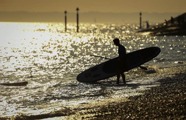 A stand up boarder enters the sea in the evening sunshine on Southsea beach on September 21, 2020 in Portsmouth. Picture: Finnbarr Webster