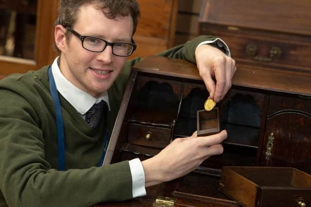 Edward Rycroft with the secret drawer and coin.