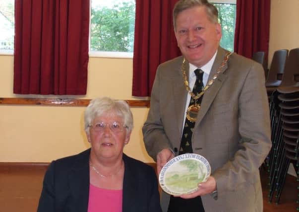 Martin Thacker, chairman of Holymoorside and Walton Parish Council, presents the award to  Anne White.