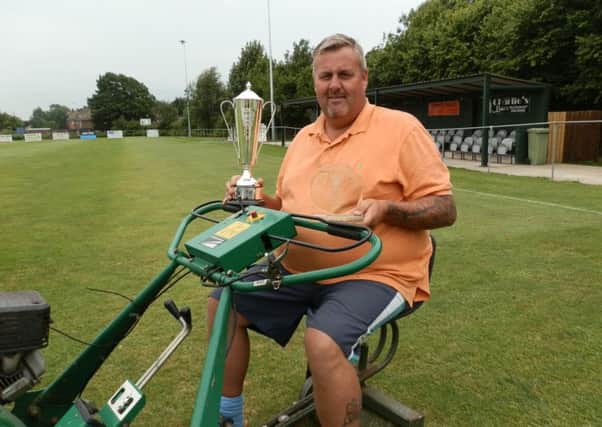 Groundsman Lee Watson, with one of his former trophies, hard at work at Clay Cross Town.