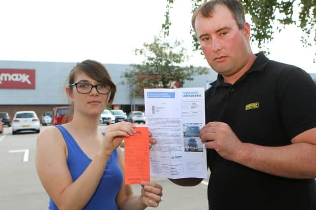 Andrew Peck and fiance Kimberley Winnals with the parking fine and his receipt for using the store