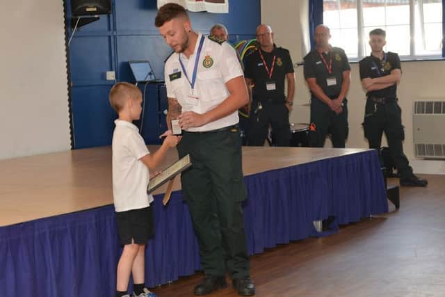 Mitchell Taylor received a bravery medal from EMAS at a special assembly at Cavendish Junior School, Mitchell is pictured with 999 call handler Kyle Thacker