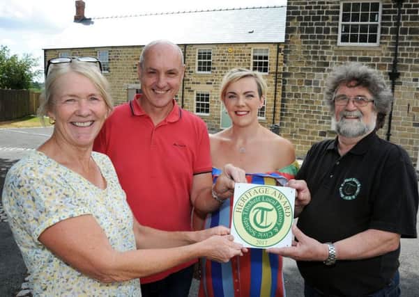 Mike Coupe, right, the secretary of the Tibshelf Local History and Civic Society, presents a Heritage Award plaque to Jennie, Paul and Laura Housley for their work on Wheatsheaf Mews, formerly the old Wheatsheaf Hotel.