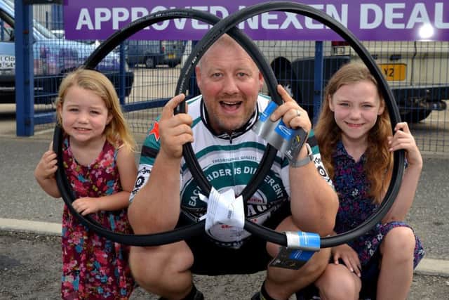Chris Miller is taking part in a charity bike ride raising money for Cancer Research, Chris is pictured with Daughters Isobelle, three and Phoebe, nine