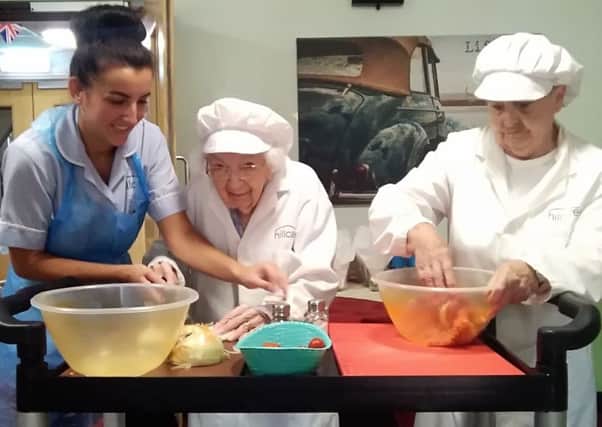 Holmewood Care Home care assistant Kaye Sykes and residents
Nancy Sallis and Hazel White make burgers for fellow residents on National Burger Day.