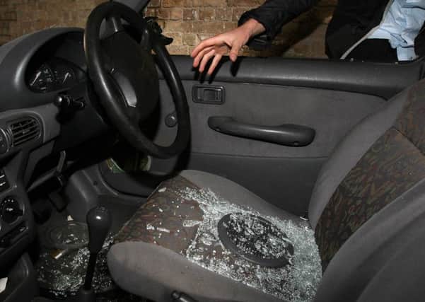Stock picture posed by model: A hand reaches into a car through a broken window. See PA story.