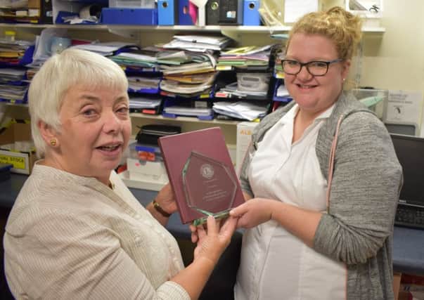 Trish Wildgoose, president of Matlock Lions Club, presents a plaque to Jo Sare, lead audiologist at Chesterfield Royal Hospital.
