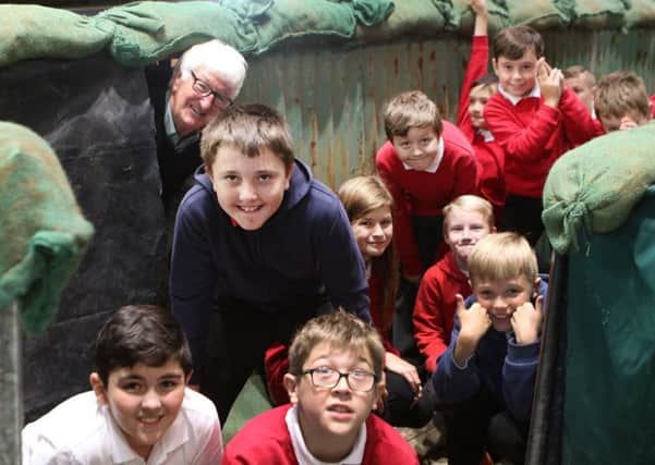 David Nightingale showing a group from Highfields Hall Primary around his trench built in the church's choir stalls