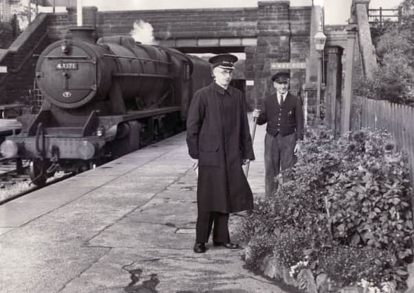 Bamford Railway Station were the winners of the special class prize and shield in the Station Gardens Competition and here Stationmaster, F. Bamford, and a porter admire some of the blooms as a goods train passes through - 4th October 1956