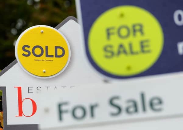 File photo dated 14/10/14 of Sold and For Sale signs. Annual house price growth has slowed to its lowest levels since May 2013, according to an index.
