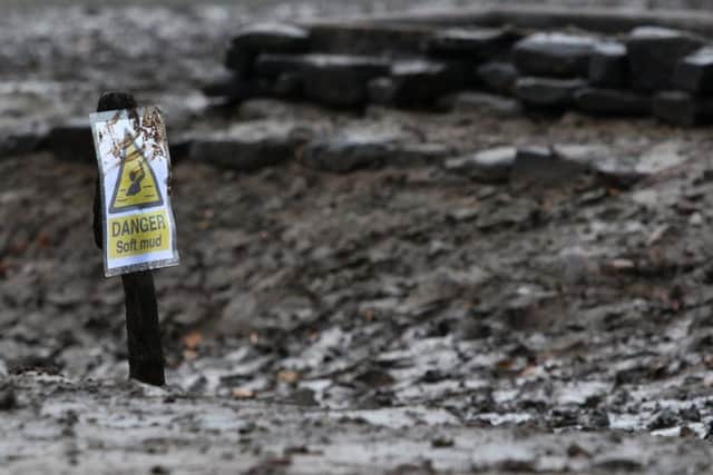 Signs warn visitors to be careful after a number of people became stuck in the mud