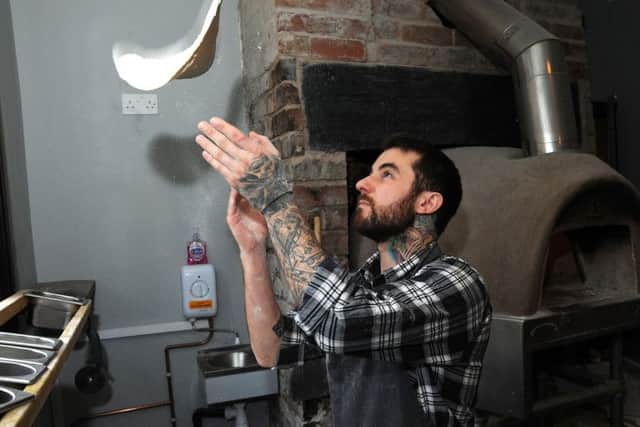 Ricky Marples, owner of Pizza Pi, on Beetwell Street, prepares his pizza bases.