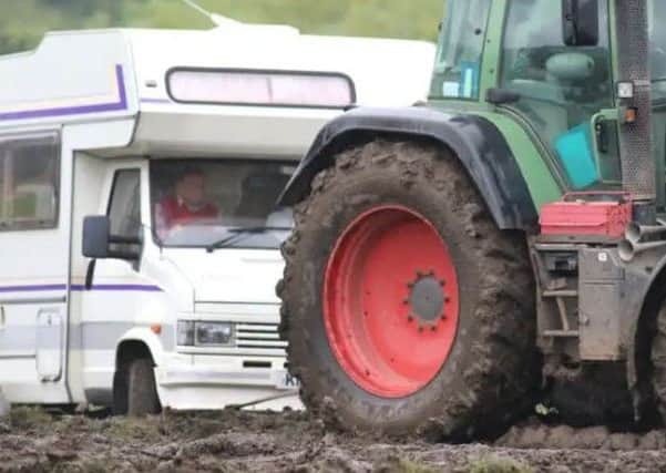 A tractor pulling a caravan out of the mud at Bakewell Show in 2017.