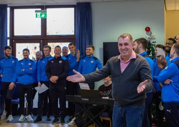 Manager Martin Allen leads the Christmas carol-singing. (PHOTO BY: Tina Jenner).