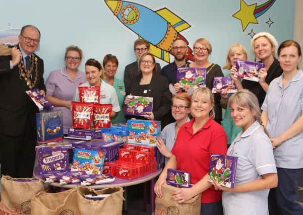 The Mayor and Mayoress help COOP staff hand over a mountain of sweets to the children's ward at Chesterfield Royal
