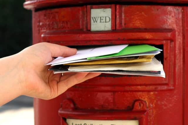 posting many letters to red british postbox on street