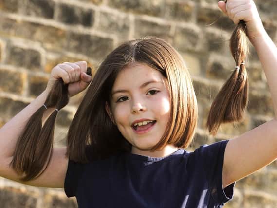 Isabelle Hare holds up her locks which she is donating to the Little Princess Trust.