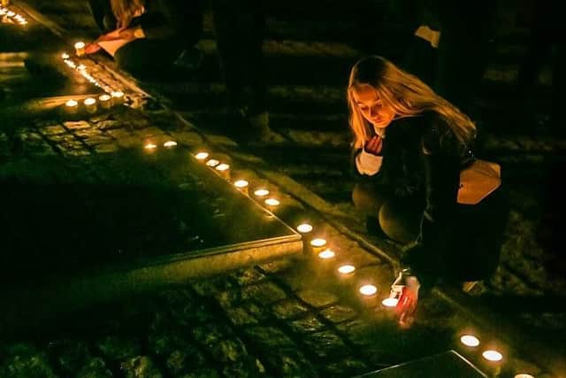 A student lights a candle in memory of lives lost. Picture: Yakir Zur