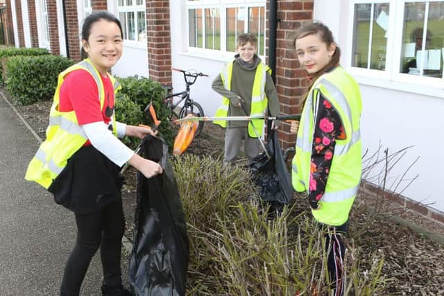 Cindy, Charlie and Gracie clearing up the school grounds.