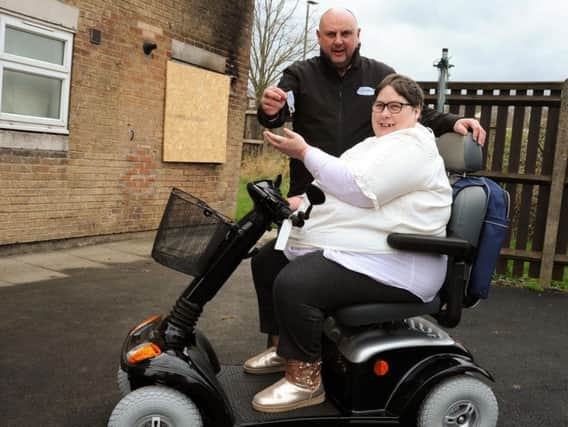 Lee Jagger, of Eden Mobility, hands over the keys to a replacement scooter to Angela Rhodes after her last one set on fire at her home in Staveley. Picture by Anne Shelley.