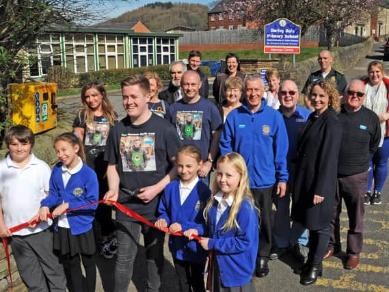 Joe Robinson cuts the ribbon at the newly-installed defibrilator at Darley Dale Primary School on Wednesday after a major fundraising drive by the community. Pictures by Anne Shelley.