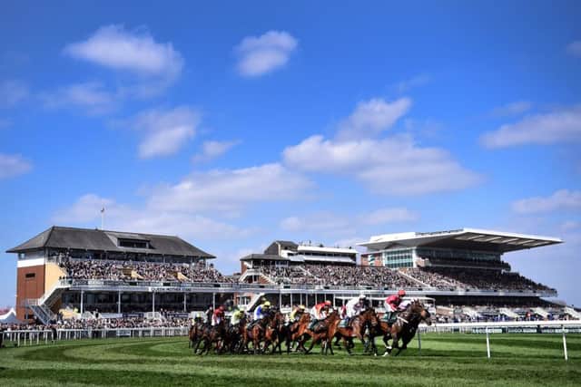 The Grand National unfolds in front of packed stands at Aintree (PHOTO BY: Laurence Griffiths/Getty Images)