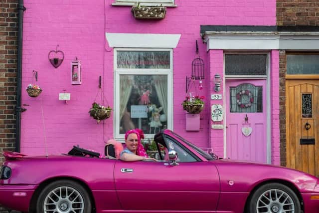 Sally Owens outside her bright pink house