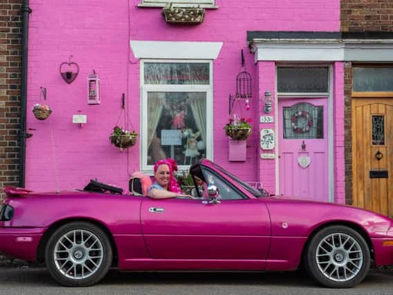 Sally Owens outside her bright pink house