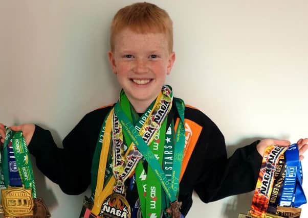 Nine-year-old Riley Parker-McCulloch with his haul of Brazilian jiu-jitsu medals.