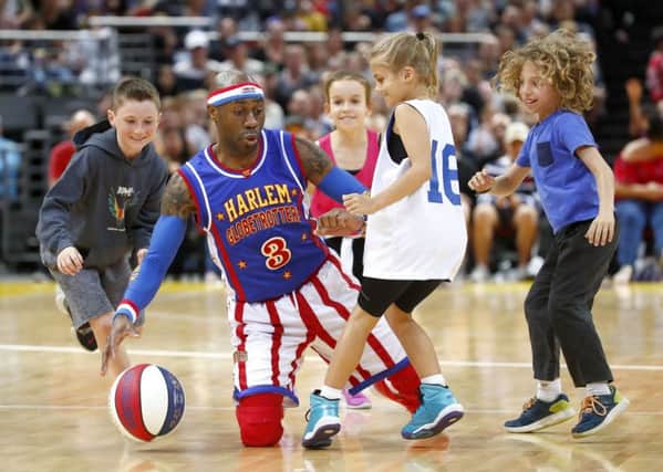 Firefly of the Globetrotters plays tricks with some kids.  Photo by Daniel Munoz/Getty Images.