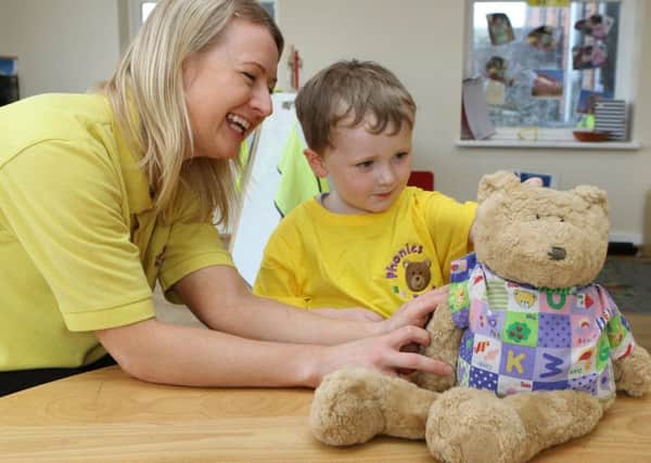 Annette Firth introduces one of the youngsters to the Phonics Bear