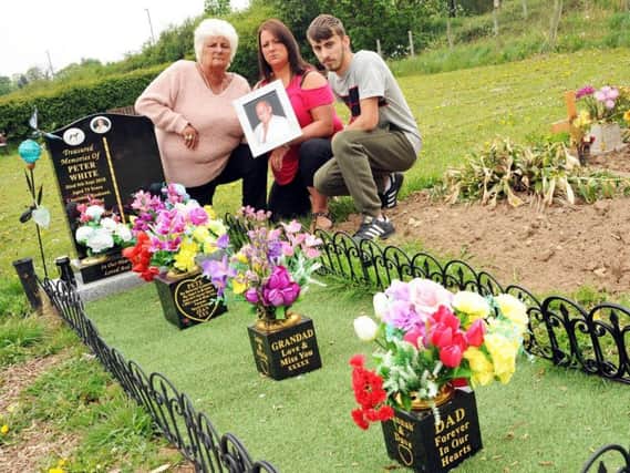 Jean White with her daughter, Hannah Skelly, and grandson Joshua James, at her husband's grave.