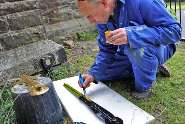 Jason Budd from Cumbria Clock Company applies the gold leaf to the St Bartholomew's Church clock hands in Clay Cross.