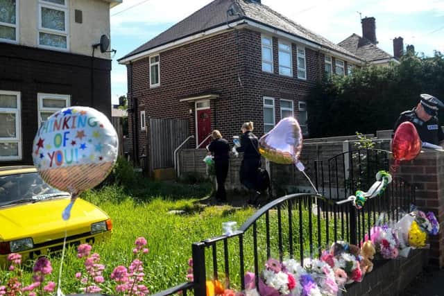 Floral tributes and balloons have been left at the scene. Photo - SWNS