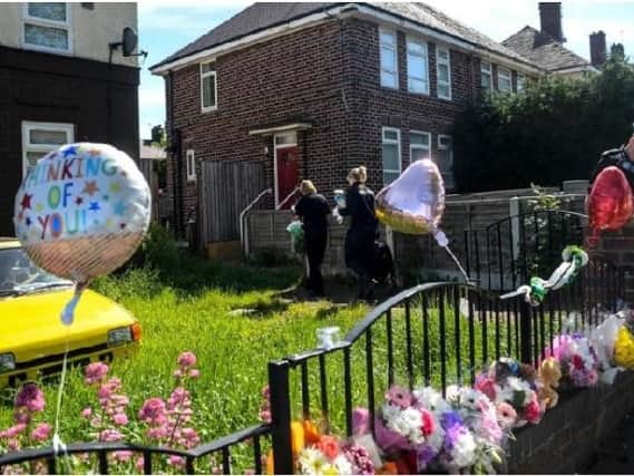 Floral tributes and balloons have been left at the scene. Photo - SWNS