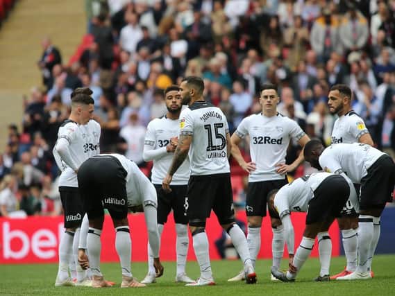 Derby County's player gather after falling behind.