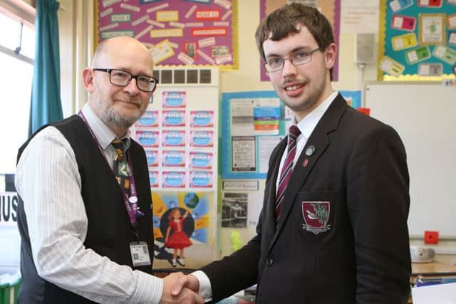 Joshua Tann who has never missed a day in twelve years of school is congratulated by his form tutor Nick Davey