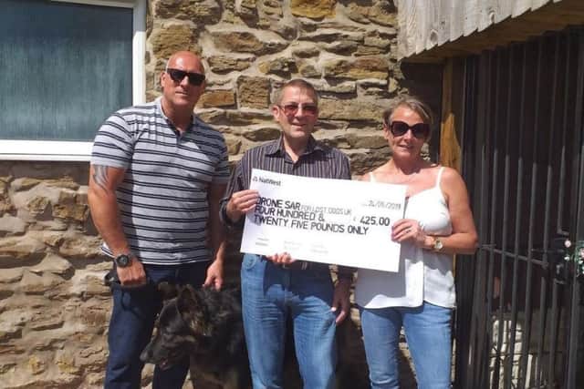 Sue and Steve Schofield present a cheque to Drone SAR for Lost Dogs UK.