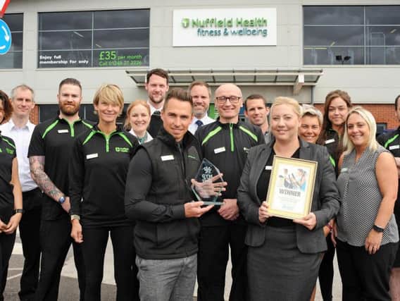 Richard Brand, the general manager of Nuffield Health Fitness and Wellbeing, and his deputy Elaine Topham,  with staff after they were presented with the trophy.