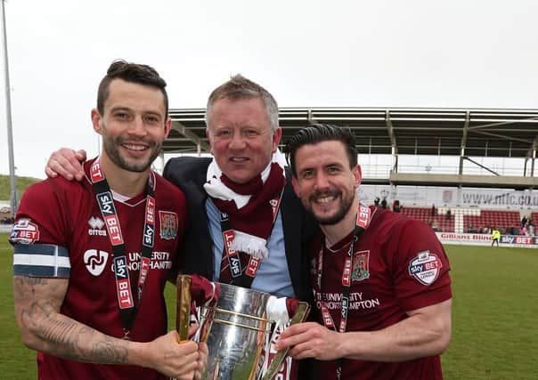 NORTHAMPTON, ENGLAND - APRIL 30:  Marc Richards( left),David Buchanan and manager Chris Wilder of Northampton Town celebrate with the Sky Bet League Two champions trophy after the Sky Bet League Two match between Northampton Town and Luton Town at Sixfields Stadium on April 30, 2016 in Northampton, England.  (Photo by Pete Norton/Getty Images)