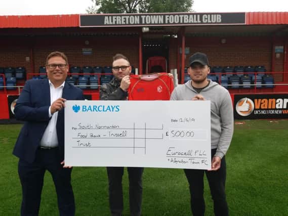 Pictured are Eurocell head of marketing, Chris Coxon, with Ross Fairhurst, the firm's digital marketing manager and Alfreton Town FC midfielder Jordan Sinnott with a cheque for 500 for the South Normanton Foodbank - Trussell Trust.