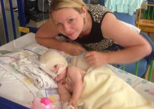 Lucy as a baby in hospital with mum Tracey.