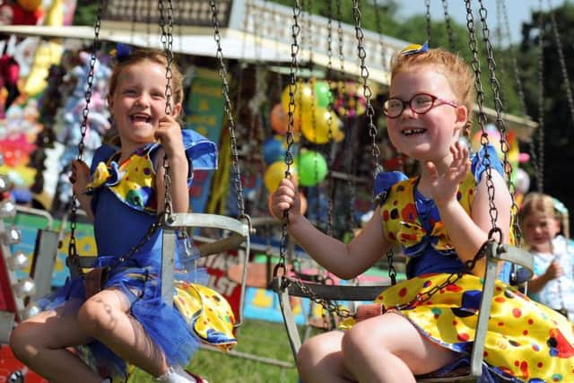 Georgia Spray, 5 and her pal Eva-Mai Whitehead 6, whip up some breeze on the fairground swing.