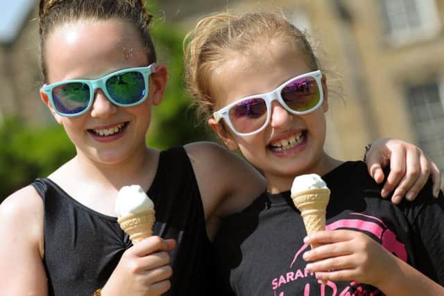Freya Puttock and Jazmyn Price both 10, cool off with ice cream after a magic carpet ride on the Aladdin float.
