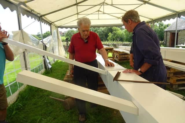 Fitting a sail bar are John Boucher and Dave Land.