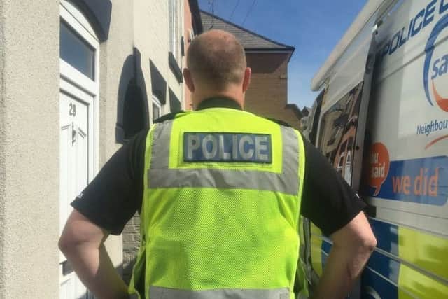 A police officer outside the Marsden Street property.